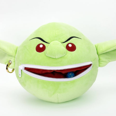 Green plush toy with a zipper mouth on a white background