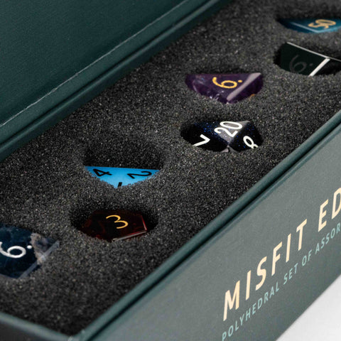 Set of polyhedral dice with gemstone-like finish in a 'Misfit Edition' box.