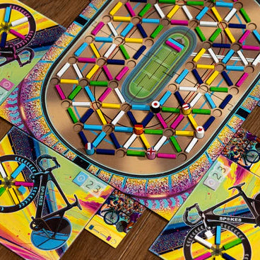 Colorful board game with bicycle-themed pieces on a wooden surface