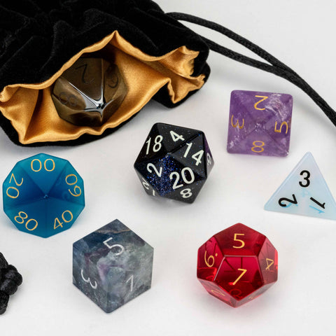Set of colorful polyhedral dice with a drawstring bag on a white background
