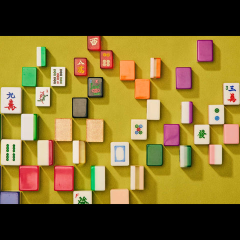 Colorful Mahjong tiles arranged on a yellow background