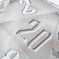 Close-up of a silver polyhedral die with numbers