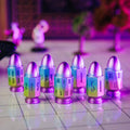 Colorful bullet-shaped objects with numbers on a reflective surface.