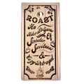 Wooden sign with engraved text and decorative elements on a wooden surface