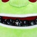 Green plush toy with a zipper mouth displaying dice