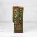Decorative wooden box with green accents on a white background