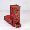 Decorative red and brown pen holder with intricate carvings on a white wooden background