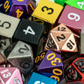 Assorted colorful dice with various numbers and lettering on a dark background