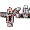 A set of metallic silver bullet-shaped items with red blood-splatter details and black numbers, arranged on a white background with one in sharp focus in the foreground and several blurred in the background.