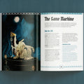 Open book showing a page with an illustration of a mechanical creature and text titled 'The Game Machine'.
