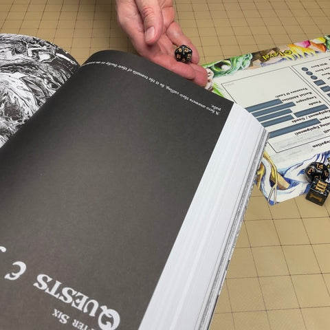 Open book with a hand holding dice on a tiled floor