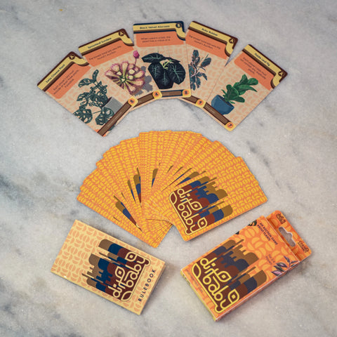 Collection of plant-themed cards and packaging on a gray surface