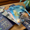 Board game components on a wooden table with a plant in the background