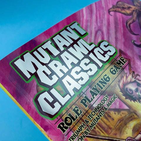 Role-playing game box titled 'Mutant Crawl Classics' against a blue sky background