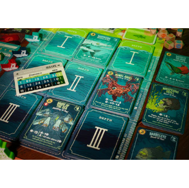 Board game cards with various illustrations and text on a wooden surface