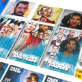 Close-up of a board game card layout with illustrated character portraits, text such as 'Solid Alibi,' 'Blood, Ink, and Tears,' and 'Natural Causes,' plus small yellow numbered tokens and a blue box edge.
