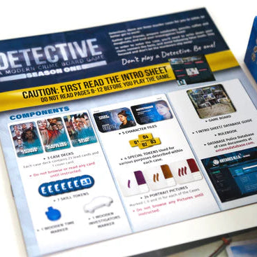 A printed game instruction sheet titled 'Detective: A Modern Crime Game Season One' is shown on a white surface, with part of its blue retail box visible at the right edge. The sheet includes component lists, character cards, and setup instructions.