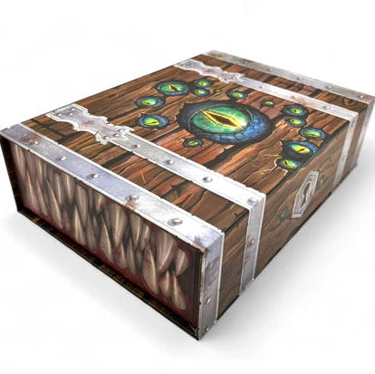 A fantasy-themed wooden chest with metallic silver straps and rivets, featuring a green eye design on the lid and a textured side panel resembling scales or teeth, shown on a white background.