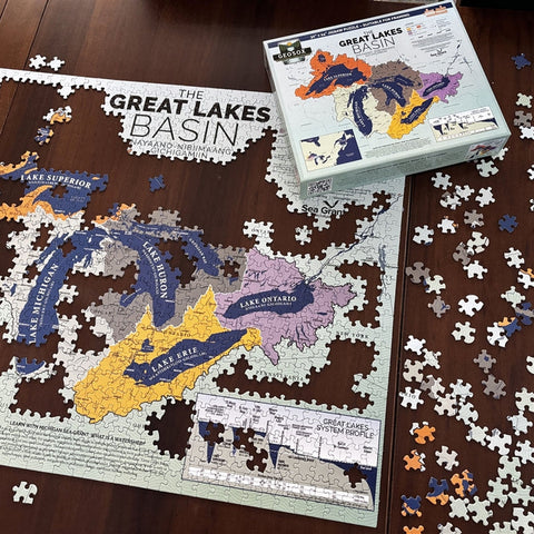 Jigsaw puzzle of the Great Lakes Basin on a wooden surface with packaging.