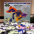 Jigsaw puzzle of the Great Lakes Basin with completed pieces in the foreground