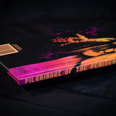 Book titled 'Pilgrimage of the Penitent' with a colorful cover on a dark background