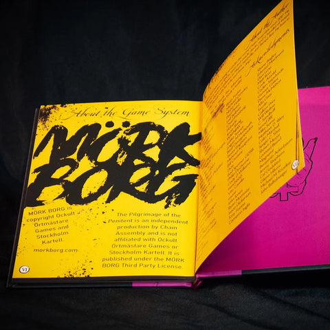 Open book with yellow and pink pages on a black background