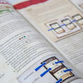 Open book with text and illustrations, focusing on a card with blue arrows.