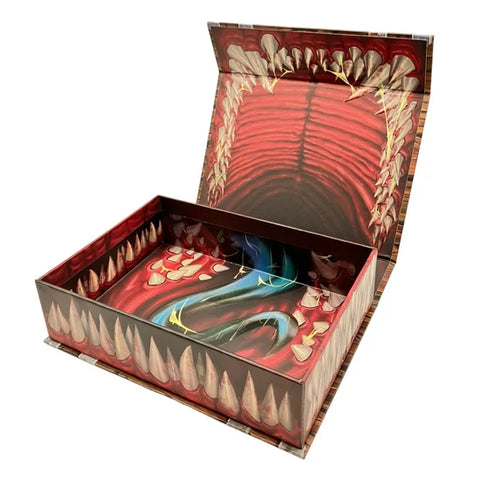 An open decorative box with a highly detailed illustration of a red mouth interior, sharp teeth, and a blue serpent winding through the base, shown on a plain white background.