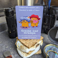 S'mores card with cartoon characters on a camping scene with flashlight, knife, and compass.
