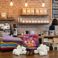 Coffee shop interior with roasted coffee beans, marshmallows, and a colorful box on a counter.