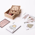 Wooden box with playing cards featuring nature-themed designs on a white background