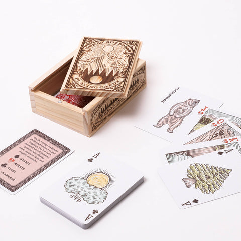 Wooden box with playing cards featuring nature-themed designs on a white background