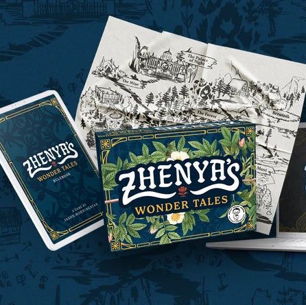 Zhenya's Wonder Tales deck box, a playing card, and a laptop displaying the game's artwork, arranged on a dark blue illustrated background.